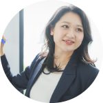 ペンを持ち微笑む女性